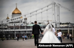 Un cuplu pe malul râului Moscova, în fața Catedralei Hristos Mântuitorul din capitala rusă, august 2020.