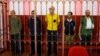 Left to right: Andrew Hill (Britain), Dylan Healy (Britain), Vjekoslav Prebeg (Croatia), John Harding (Britain), and Mathias Gustafsson (Sweden), stand in a defendants' cage as they attend a court hearing in Donetsk, Ukraine, on August 15, 2022.