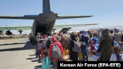 Afganët që kanë punuar për koreanët e jugut dhe anëtarët e familjes së tyre hipin në një aeroplan ushtarak të Koresë së Jugut në aeroportin e Kabulit më 25 gusht 2021. 