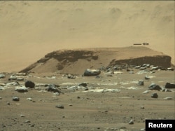 یک صخره سنگی بلند با رسوبات لایه‌ای که نشانه‌ای از بقایای یک رودخانه در مریخ است