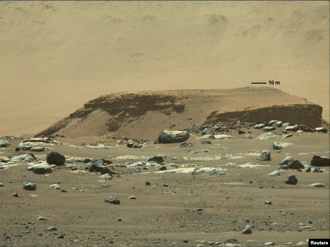 یک صخره سنگی بلند با رسوبات لایه‌ای که نشانه‌ای از بقایای یک رودخانه در مریخ است