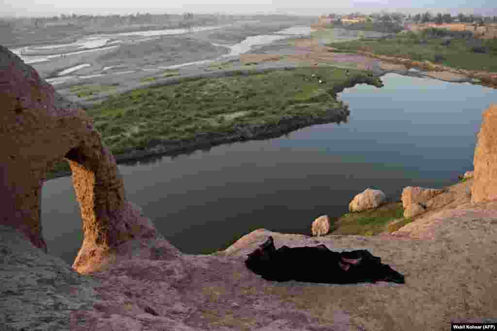 An Afghan man rests at an abandoned structure overlooking the Lashkar Gah River in Helmand Province. (AFP/Wakil Kohsar)​