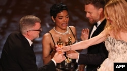 Режисьорът на "Битка след битка" Пол Тoмас Андерсън (вляво) и актрисата Teяна Тейлът (в средата) приемат от Юън Макгрегър и Никол Кидман наградата "Оскар" за най-добър филм, 15 март 2026 г.
