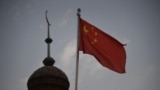 China - This photo taken on June 4, 2019 shows the Chinese flag flying over the Juma mosque in the restored old city area of Kashgar, in China's western Xinjiang region. - While Muslims around the world celebrated the end of Ramadan with early morning pra