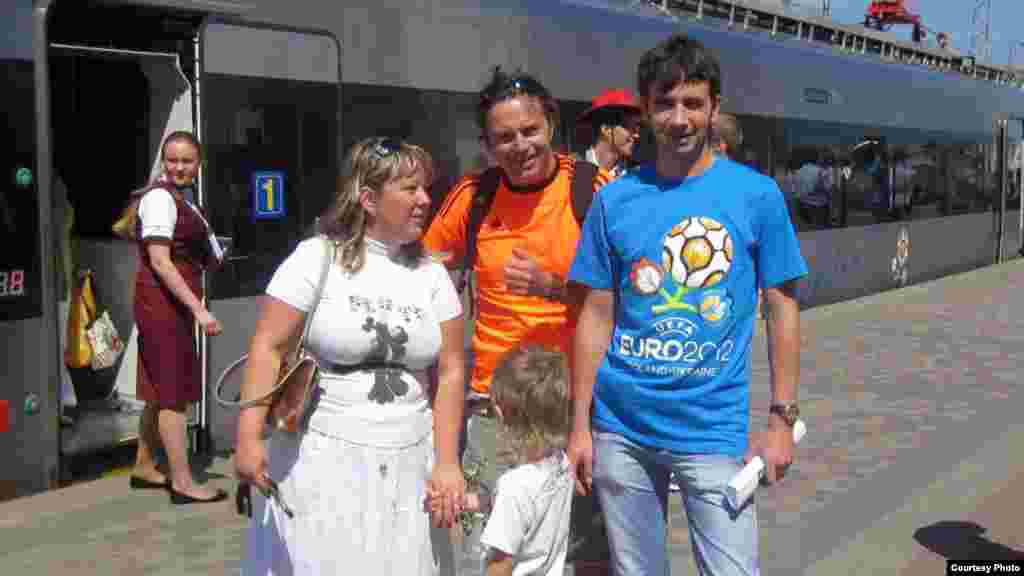 Irina Toldina, a 31-year-old lawyer from Kharkiv, her husband, Oleg (right), and son Yaroslav, 5, welcome visiting Dutch fan John, who came to Kharkiv for the Netherlands vs. Denmark match on June 9.