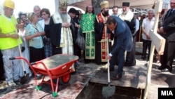 Russian businessman Sergei Samsonenko (holding shovel) helps lay the cornerstone for the Holy Trinity Russian Orthodox church in Skopje. 