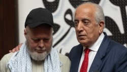 US citizen Dennis Coyle (left), upon his release by the Taliban, addresses the media with US former special envoy to Afghanistan Zalmay Khalilzad at the airport in Kabul on March 24.