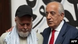 US citizen Dennis Coyle (left), upon his release by the Taliban, addresses the media with US former special envoy to Afghanistan Zalmay Khalilzad at the airport in Kabul on March 24.