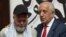 US citizen Dennis Coyle (left), upon his release by the Taliban, addresses the media with US former special envoy to Afghanistan Zalmay Khalilzad at the airport in Kabul on March 24.