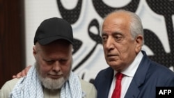 US citizen Dennis Coyle (left), upon his release by the Taliban, addresses the media with US former special envoy to Afghanistan Zalmay Khalilzad at the airport in Kabul on March 24.