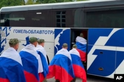 Былыя палонныя расейскія салдаты садзяца ў беларускі аўтобус