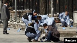 Turkish forensic police officers inspect the scene of the blast in Ankara.