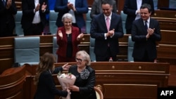 Kosovo's new President Justina Pula receives a bouquet of flowers after being elected in an extraordinary parliamentary session in Pristina.