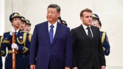 Chinese leader Xi Jinping standing next to French President Emmanuel Macron during a welcome ceremony in Beijing on December 4