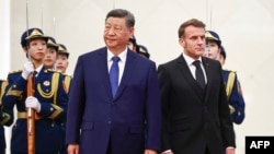 Chinese leader Xi Jinping standing next to French President Emmanuel Macron during a welcome ceremony in Beijing on December 4