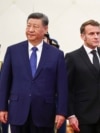 Chinese leader Xi Jinping stands next to French President Emmanuel Macron during a welcome ceremony in Beijing on December 4.