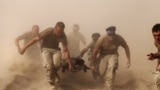 Members of the U.S. Navy carry a comrade wounded by an explosion to a medevac helicopter in southern Afghanistan October 2, 2010. 