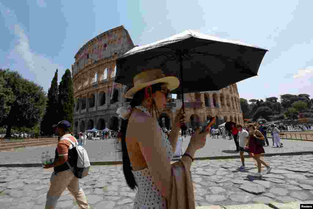 Žena se sa kišobranom štiti od sunca pored Koloseuma tokom toplotnog talasa širom Italije, jer se očekuje da će temperature u narednim danima dodatno porasti, u Rimu.