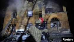 Stanovnici ispred zgrade koja je pogođenatokom ruskog napada dronom i raketama u Kijevu, 9. januar 2026.