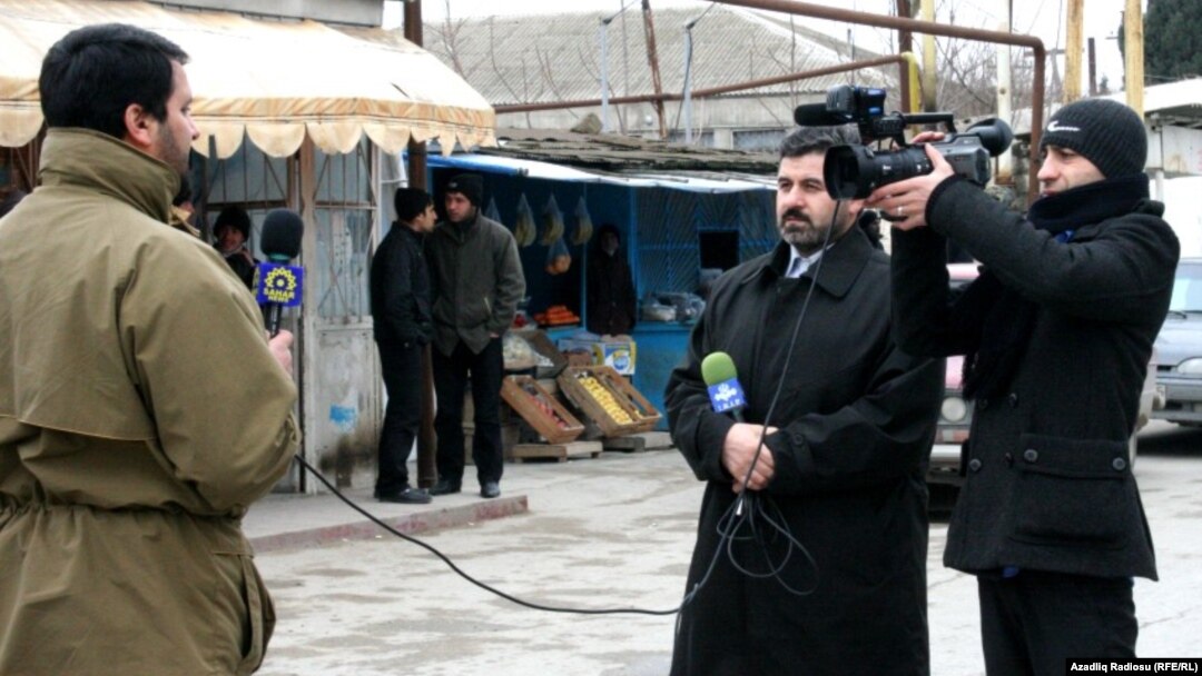 «Səhər» televiziyasının əməkdaşı Anar Bayramlı reportaj hazırlayarkən (sol tərəfdə)