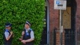 Polis məmurları Britaniya baş naziri Kir Starmerin Londondakı evinin yanğından zərər çəkən girişinin yaxınlığında dayanıblar.