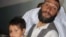 An Afghan man holds a child reportedly injured in an ISAF air strike in Herat Province on July 17