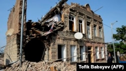 Жител на град Ганджа в Азербейджан гледа разрушена при последните ракетни атаки сграда на 27 октомври
