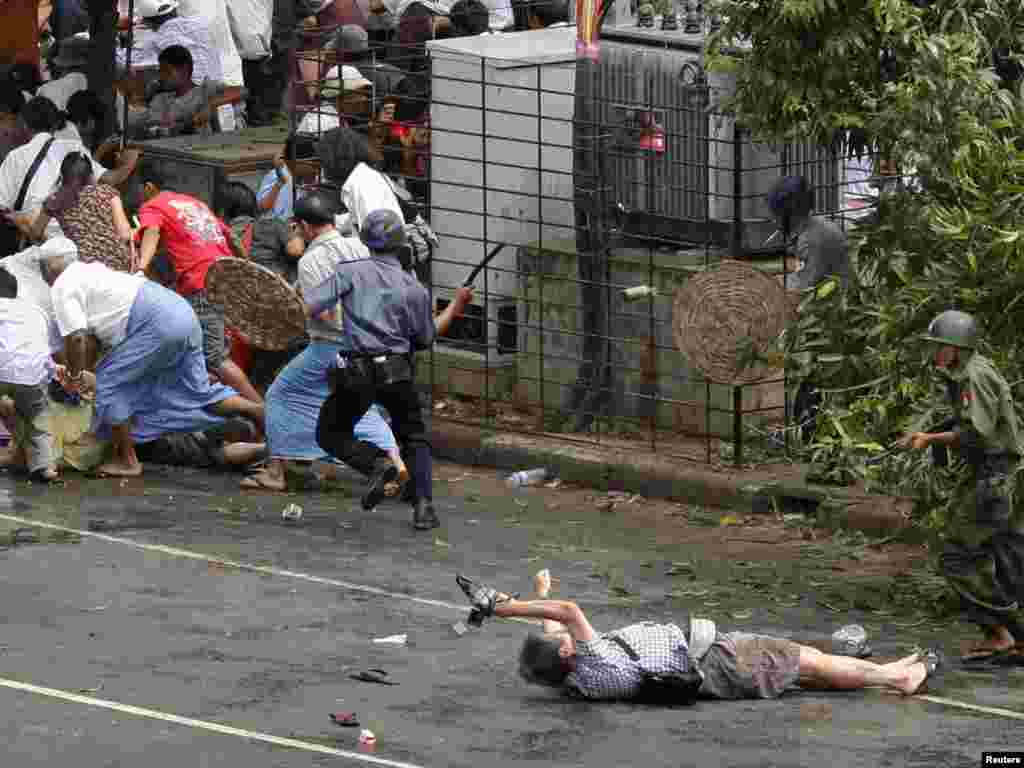 A Japanese videographer, sprawled on the pavement, fatally wounded during a street demonstration in Myanmar, Kenji Nagai of APF tries to take photographs as he lies injured after police and military officials fired upon and then charged at protesters in Yangon's city centre September 27, 2007. Nagai, 50, a Japanese video journalist, was shot by soldiers as they fired to disperse the crowd. Nagai later died. REUTERS/Adrees Latif 