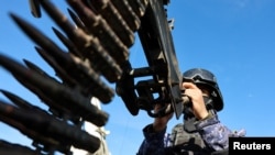 A Houthi police trooper mans a machine gun mounted on a patrol vehicle at a rally in solidarity with Iran in Sanaa, Yemen