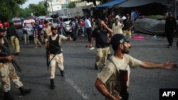 Pakistani paramilitary soldiers gather at the site of a bomb blast in Karachi on July 10.