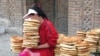 Tajikistan - A girl is selling bread in a market in Panjakent city, Apr2008