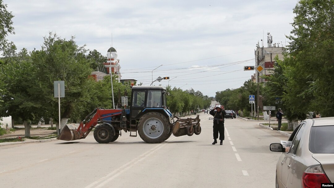 A Kazakh police officer blocks a street near the site of an exchange of fire between security forces and suspected militants linked to deadly attacks this week in Aqtobe. 