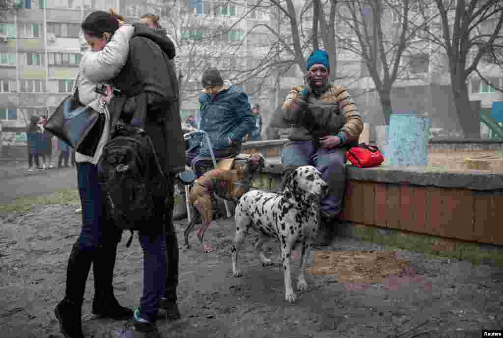 Residents of a heavily damaged 18-story apartment building gather outside following a Russian missile strike in Kyiv and other regions on February 7.
