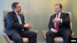 Belgium -- British Prime Minister David Cameron listens to Ukrainian President Petro Poroshenko (R) ahead of an European Union leaders summit in Brussels, February 12, 201