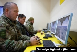 Сотрудники частного охранного предприятия используют тренажеры для обучения полетам на беспилотнике-перехватчике, Украина, 8 апреля 2026 года