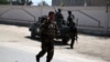 Afghan security officers stand guard outside the residence of Faridoon Momand, an Afghan lawmaker, after a suicide bomb attack in Jalalabad on June 8.