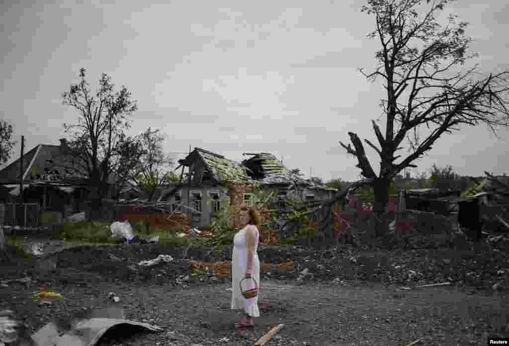 A local resident stands outside buildings damaged by a recent shelling in the eastern Ukrainian village of Semenivka on July 9. (Reuters/Gleb Garanich)