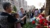 Qytetarët vendosin lule pranë shkollës ku ndodhi sulmi në Kazan të Rusisë, 11 maj, 2021.