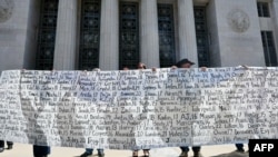 Părinți și rude afișează un banner cu numele celor pe care îi consideră victime ale practicilor rețelelor de socializare în fașa Curții Superioare din Los Angeles, după verdict. 25 martie 2026.