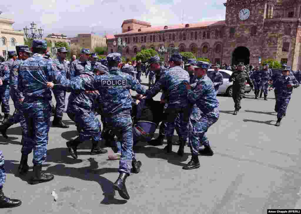 A policeman kicks a demonstrator as he is dragged into a police van in Yerevan&#39;s Republic Square.