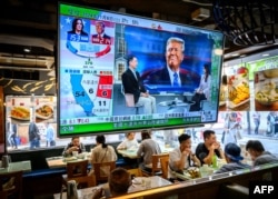 A TV screen showing preliminary results for the U.S. presidential election hangs in a restaurant in Hong Kong on November 6.