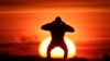 Čovek vežba tokom zalaska sunca na obali Finskog zaliva u Sankt Petersburgu, Rusija. (AP/Dmitri Lovetsky)