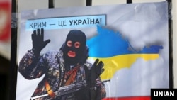 Плакат із зображенням президента Росії Володимира Путіна під час акції «Крим – це Україна» біля російського посольства в Києві, 16 березня 2020 року