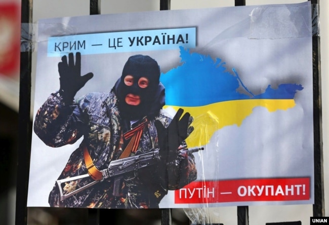 Плакат с изображением президента России Владимира Путина во время акции «Крым – это Украина» у российского посольства в Киеве, 16 марта 2020 года