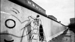 Американский художник Кит Харинг рисует на западной стороне Берлинской стены, 1986 год.