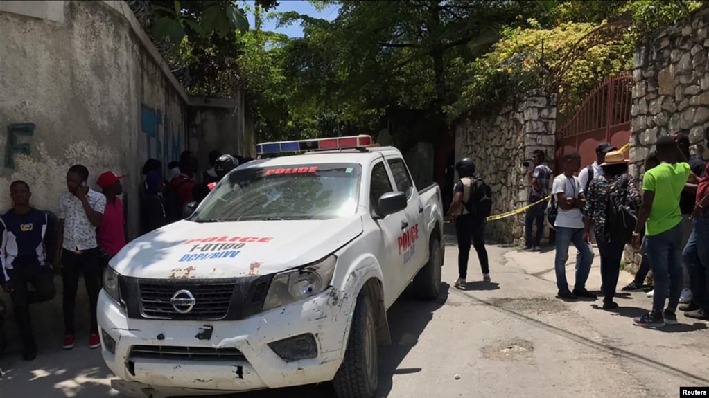Ljudi stoje pored policijskog automobila u blizini rezidencije predsednika Haitija Jovenela Moisea nakon što su ga nepoznati napadači ustrelili, Port-au-Prince na Haitiju 7. jula 2021.