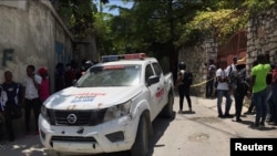 Ljudi stoje pored policijskog automobila u blizini rezidencije predsednika Haitija Jovenela Moisea nakon što su ga nepoznati napadači ustrelili, Port-au-Prince na Haitiju 7. jula 2021. 