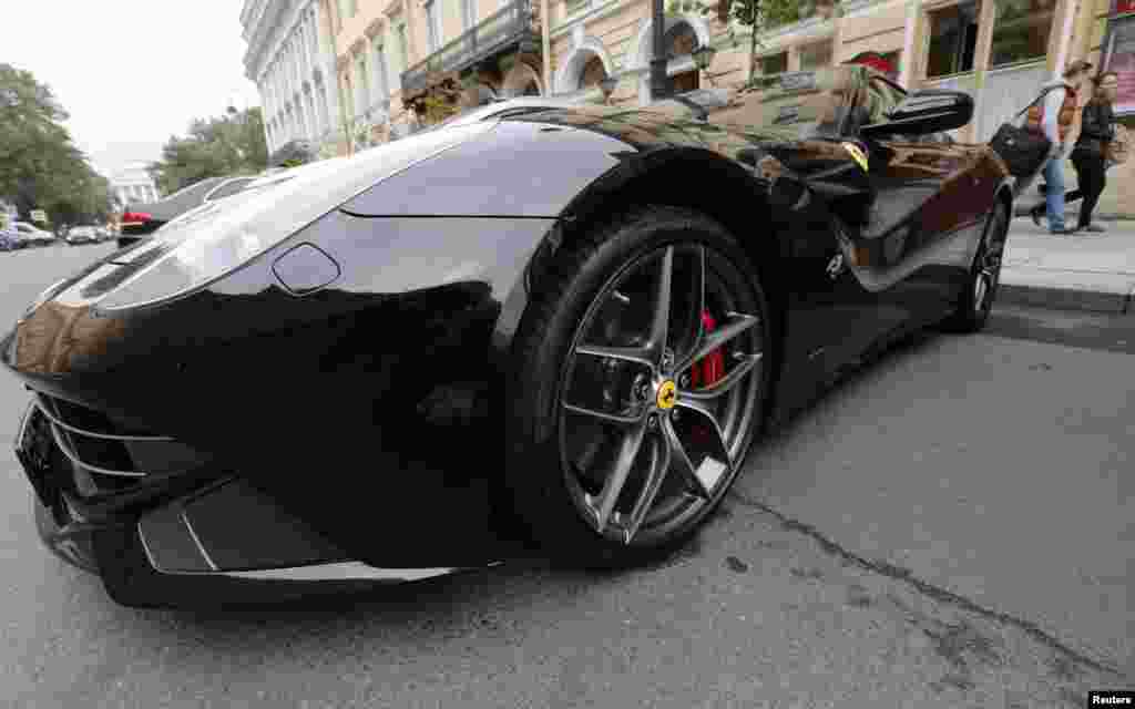 A man and woman walk past a Ferrari in St. Petersburg, Russia. (Reuters/Alexander Demianchuk)