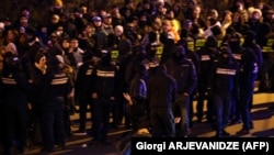 Georgian security personnel in Tbilisi drag down a protester on February 2.