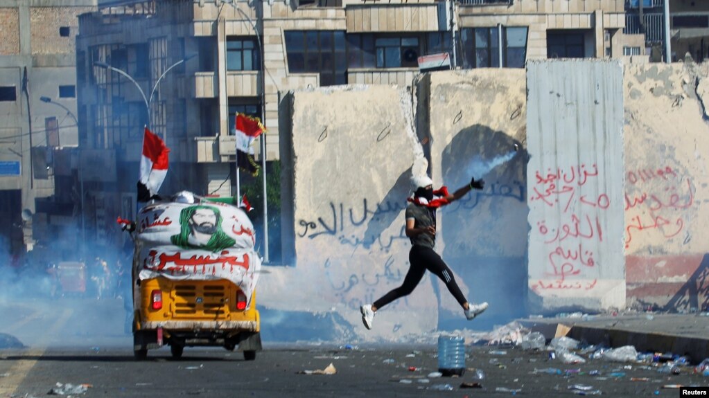 A demonstrator throws away a tear gas canister during an anti-government protest in Baghdad on November 1.